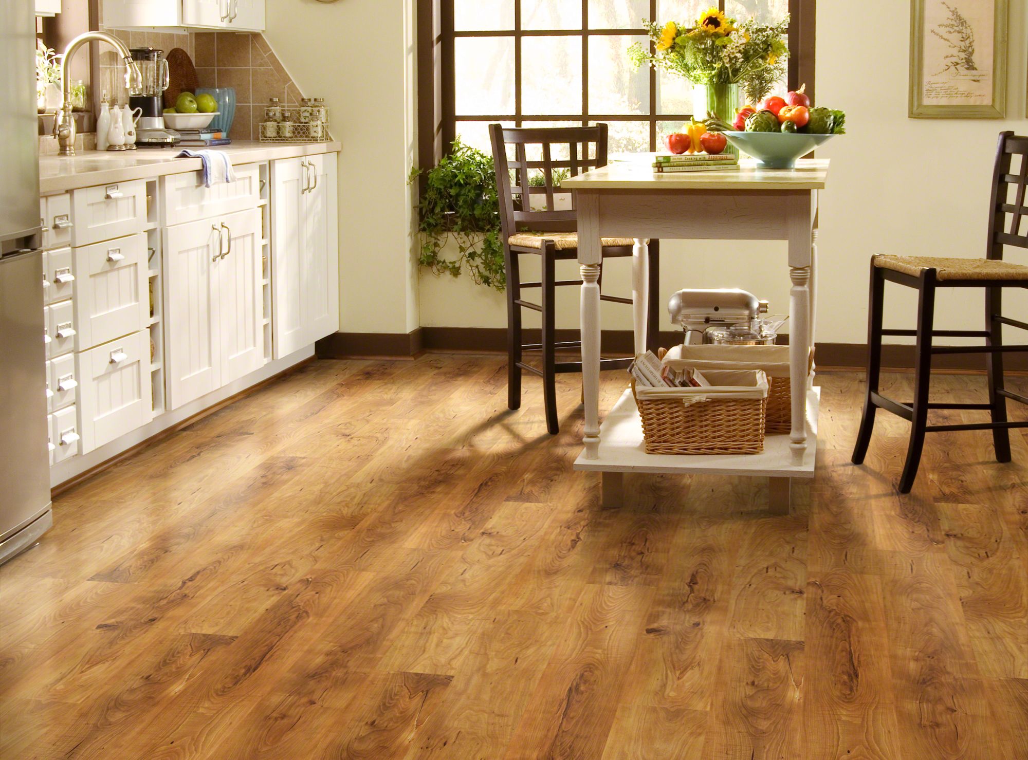 Laminate flooring in a kitchen, patterned to look like a hardwood floor