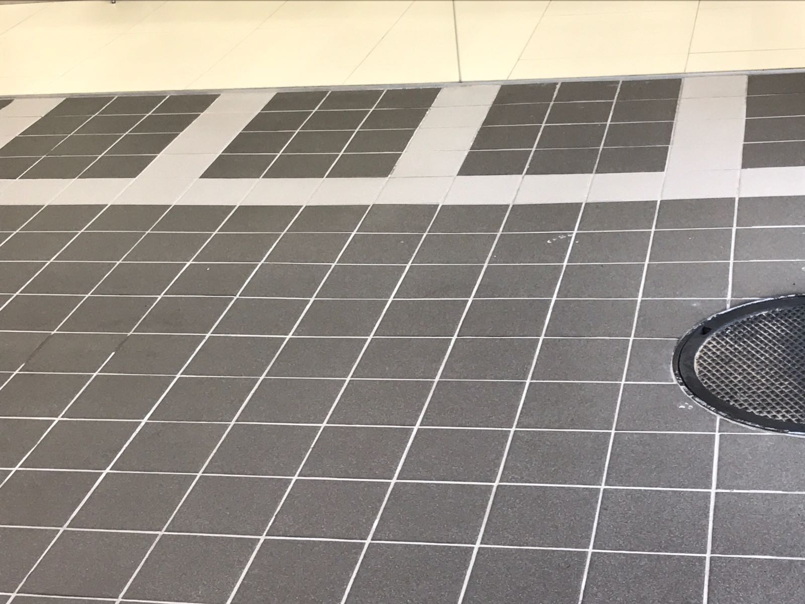 Close up of the floor of a shower stall with black and white tiling